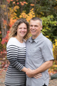 couple in front of fall leaves